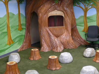 Here's a preschool space we created featuring a tree playhouse with an interchangeable TV and puppet theater.	